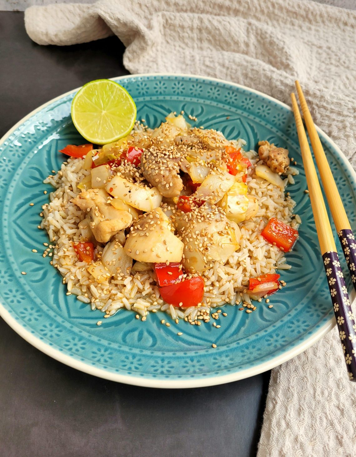 Oosterse wokschotel met witlof, paprika, kip, rijst en sesamzaadjes op een bord (low FODMAP, glutenvrij, lactosevrij)