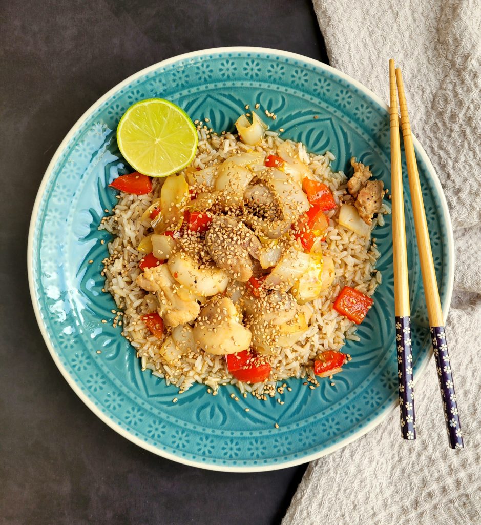 Oosterse wokschotel met witlof, paprika, kip, rijst en sesamzaadjes op een bord (low FODMAP, glutenvrij, lactosevrij)